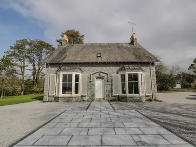 an old stone house with a dog on top of it at Auchenvhin - Rockcliffe in Dalbeattie