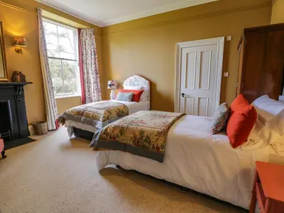 a bedroom with two beds and a fireplace at Auchenvhin - Rockcliffe in Dalbeattie