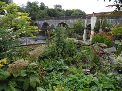 a garden with a stone bridge and flowers at The Haven B&B in Castle Douglas