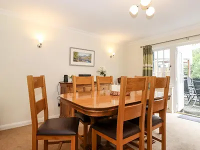 a dining room with a wooden table and chairs at Holly Cottage in Ambleside