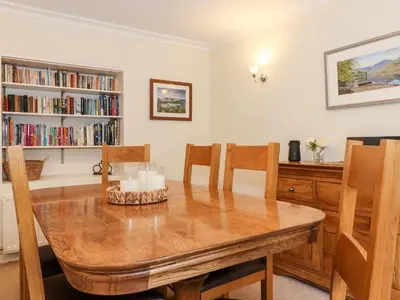 a dining room with a wooden table and chairs at Holly Cottage in Ambleside