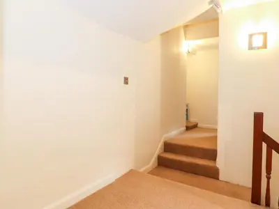 a hallway with stairs in a house at Holly Cottage in Ambleside