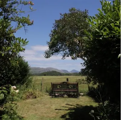 a bench sitting in the middle of a field at Roses Cottage cosy countryside home with open fire and mountain views near Scafell in Santon Bridge
