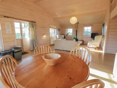 a dining room with a wooden table and chairs at Lapwing Lodge in Dumfries