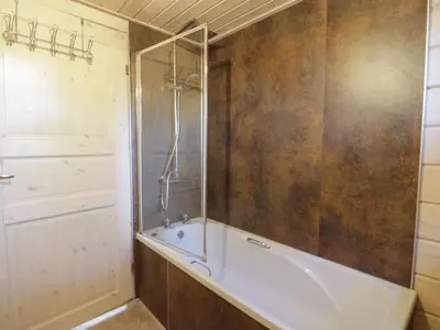 a bathroom with a tub and a glass shower at Lapwing Lodge in Dumfries