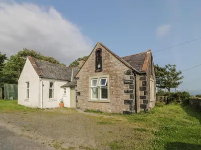 an old stone house on the side of a road at West Lodge in Dumfries