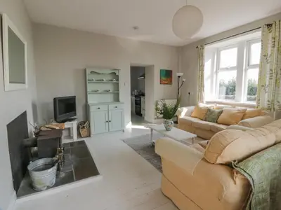 a living room with a couch and a tv at West Lodge in Dumfries