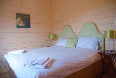 a bedroom with a bed in a wooden room at Skylark Lodge in Dumfries