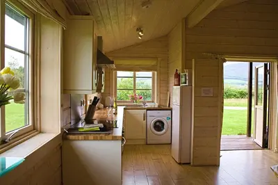 a kitchen with a refrigerator and a washing machine at Skylark Lodge in Dumfries