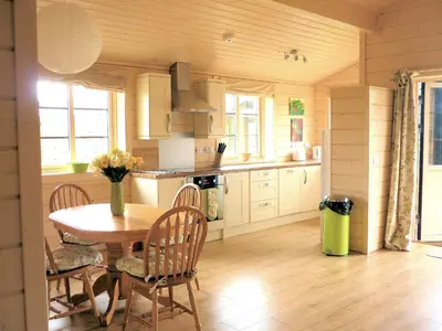 a kitchen with a table and chairs in a room at Skylark Lodge in Dumfries