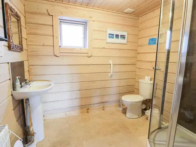 a bathroom with a toilet and a sink at Curlew Lodge in Dumfries