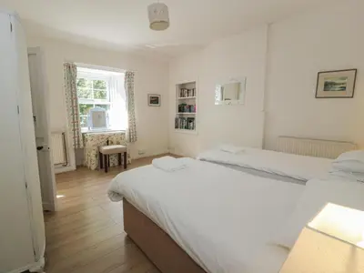 a bedroom with two beds and a window at Little Dunbar Cottage in Dumfries