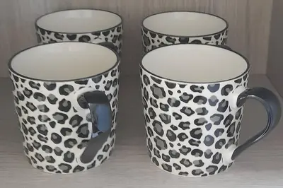 two black and white mugs sitting on a table at Kirkcudbright Holiday Apartments - Apartment F in Kirkcudbright