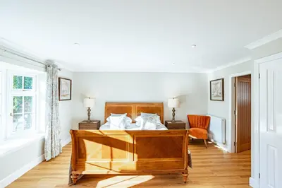 a bedroom with a bed and a window at Sparrowhawk Cottage with Hot Tub in Newton Stewart
