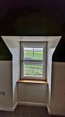 a window in a room with a green wall at Nordlys Cottage in Newton Stewart