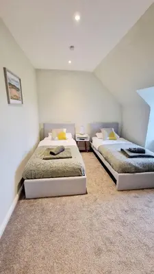 two beds sitting in a room with at Nordlys Cottage in Newton Stewart