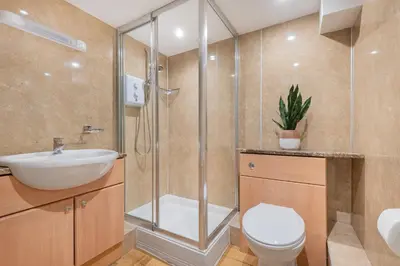 a bathroom with a shower and a toilet and a sink at cottage 7 old farmhouse mews in Keswick