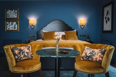 a bedroom with a bed and a table and chairs at Bridge House Hotel & Silver Howe View Cottage in Grasmere