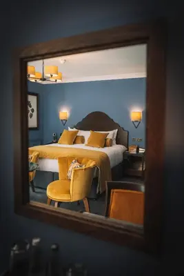 a bedroom with a large bed and a mirror at Bridge House Hotel & Silver Howe View Cottage in Grasmere