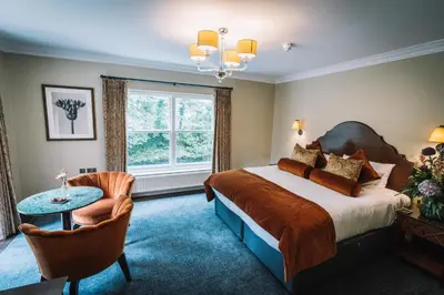 a bedroom with a bed and a table and a chair at Bridge House Hotel & Silver Howe View Cottage in Grasmere