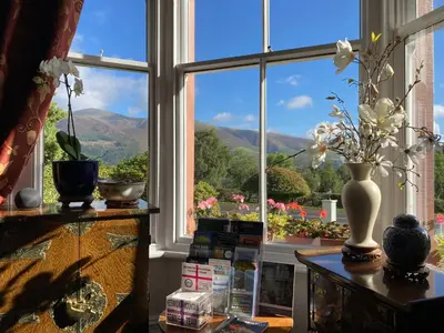 a room with a window with a view of the mountains at Maple Bank Country Guest House in Keswick