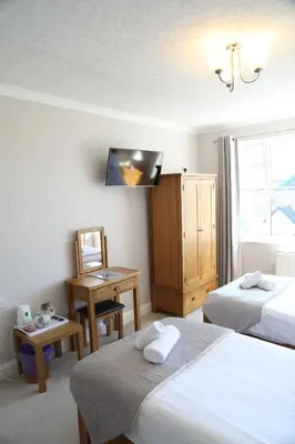 a hotel room with two beds and a television at Keswick Park Hotel in Keswick