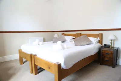 a bedroom with a large bed with white sheets and pillows at Keswick Park Hotel in Keswick