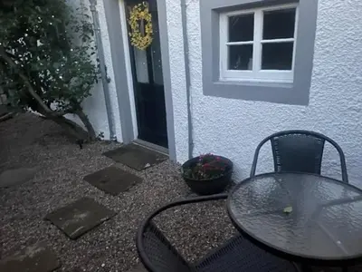 a table and chairs sitting in front of a house at White House in Carlisle
