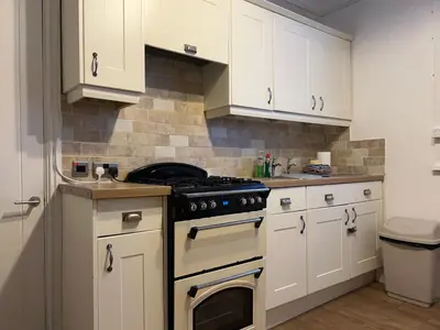 a kitchen with white cabinets and an oven at Ennerdale Edge - 4 Bedrooms - Sleeps 8 in Cleator Moor