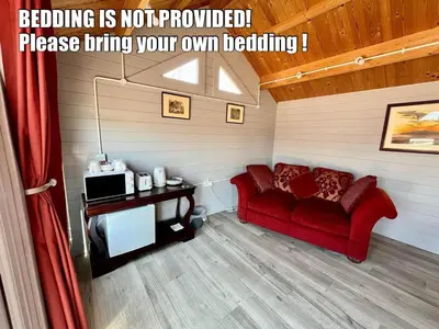 a living room with a red couch in a room at Broom Leisure Camping Pods in Annan