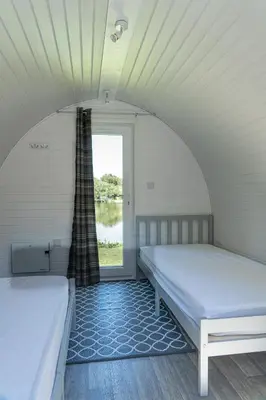 two beds in a room with a window at Broom Leisure Camping Pods in Annan