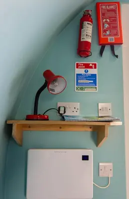 a red lamp on a wooden shelf on a wall at Broom Leisure Camping Pods in Annan