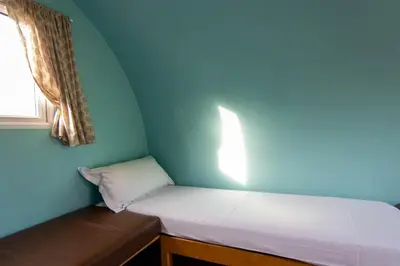 a small room with a bed and a window at Broom Leisure Camping Pods in Annan