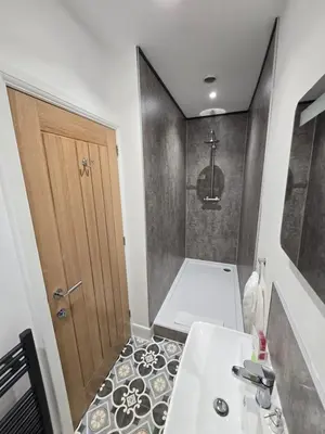 a bathroom with a sink and a wooden door at The Plough Inn in Carlisle