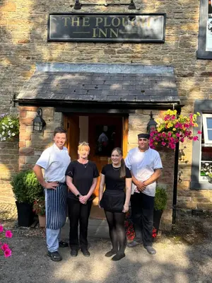 a group of people standing in front of a building at The Plough Inn in Carlisle