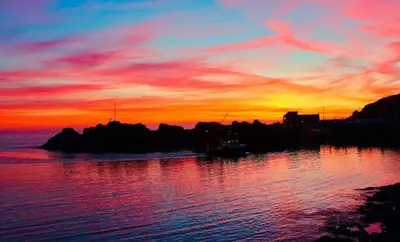 a sunset over a body of water with the sky at Lagavulin 3 in Portpatrick