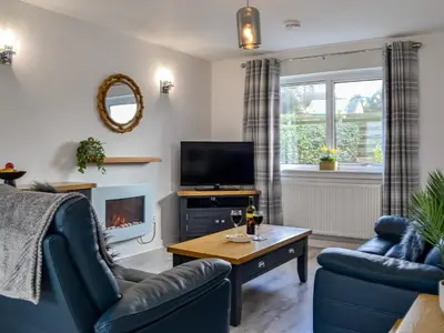 a living room with a couch and a tv at Anchor Cottage in Portpatrick
