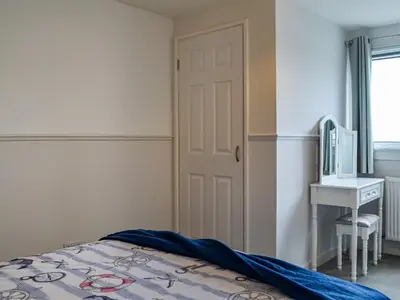 a bedroom with a bed and a desk and a tv at Anchor Cottage in Portpatrick