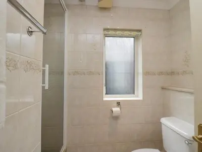 a bathroom with a shower and a toilet and a window at Dogwood Timber Lodge in Keswick