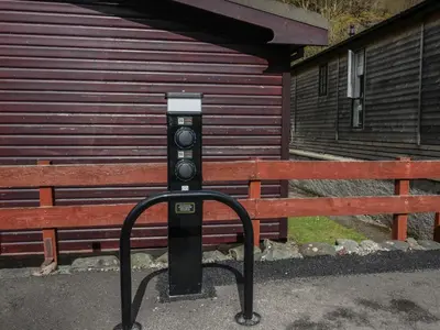 a parking meter sitting in front of a bench at Dogwood Timber Lodge in Keswick
