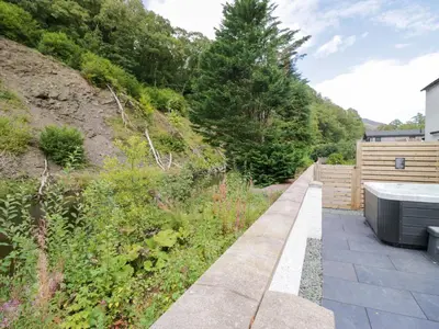 a garden with a hot tub on the side of a hill at Riverside Cottage No 4 in Keswick