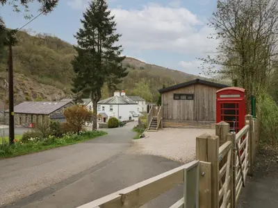 a red phone booth in front of a building at Riverside Cottage No 4 in Keswick