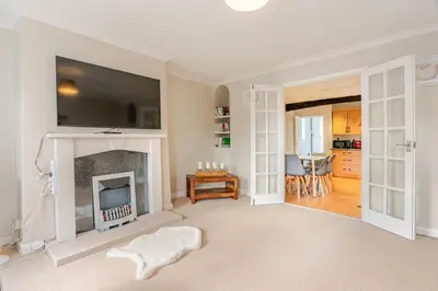 a living room with a fireplace and a tv at Hummingbird House in Cockermouth
