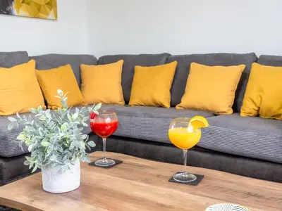 a coffee table with two wine glasses and a couch at Mountain View Beautiful Large House By Cockermouth in Cockermouth