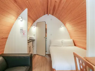 a small room with a bed and a chair at Pod No 28 in Keswick