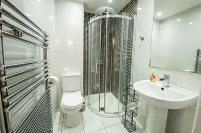a bathroom with a toilet and a shower and a sink at 25 Church Street in Keswick