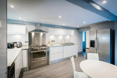 a kitchen with stainless steel appliances and a table at Greta House in Keswick