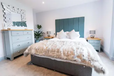 a bedroom with a large bed and a dresser at Briery House in Keswick