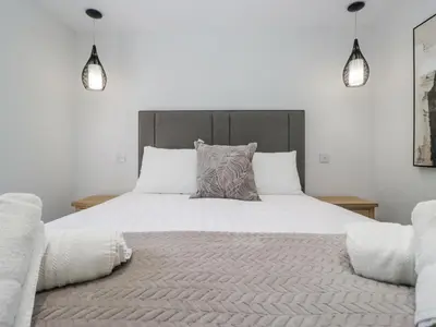 a bedroom with a large white bed with two pillows at Riverside Cottage No 3 in Keswick