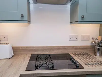 a kitchen with a stove top on a counter at Riverside Cottage No 3 in Keswick